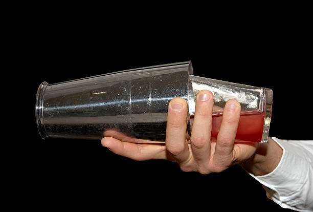 Hand holding a two-piece Boston Cocktail Shaker with red liquid, ready for mixing.