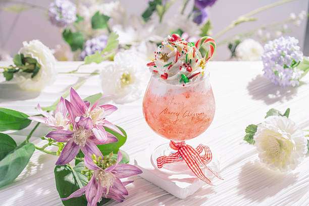 Festive pink Christmas cocktail, prepared with a Cocktail Shaker, garnished with candy cane.
